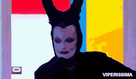a woman in a maleficent costume is standing in front of a colorful wall with the words viperissima below her