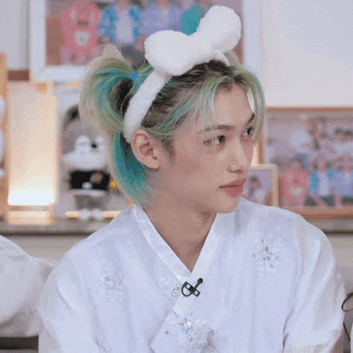 a young man with blue hair wearing a white bunny headband