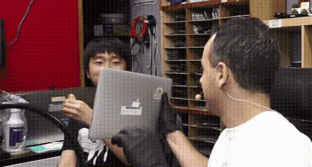 a man is holding a laptop with a sticker on it that says apple