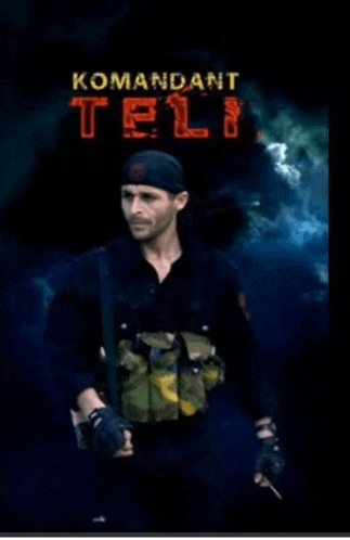 a man is standing in front of a sign that says " komandant tel "