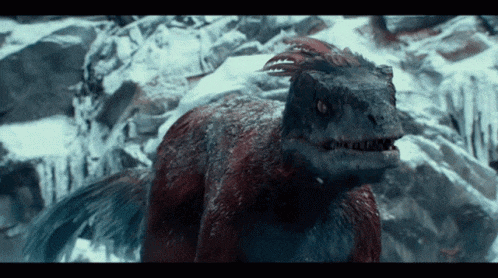 a close up of a dinosaur in the snow with its mouth open