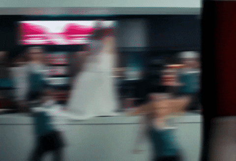 a blurry picture of people walking in front of a sign that says ' coca cola '