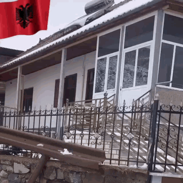 a house with a fence and a flag behind it