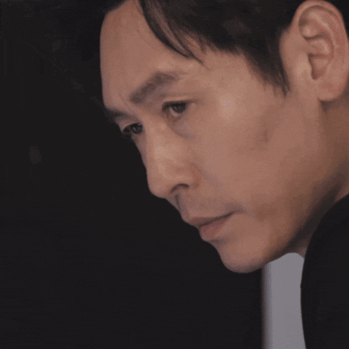 a close up of a man 's face with a black shirt on