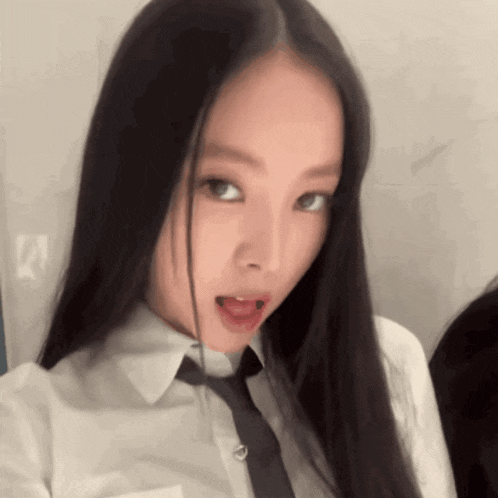 a woman with long black hair is wearing a white shirt and tie .