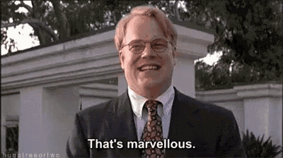 a man in a suit and tie is laughing and saying that 's marvellous .