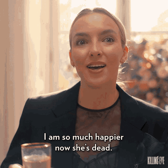 a woman is holding a glass and saying i am so much happier now she 's dead
