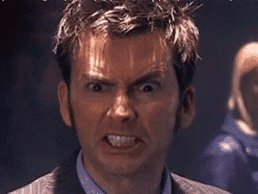 a man in a suit is making a very angry face .