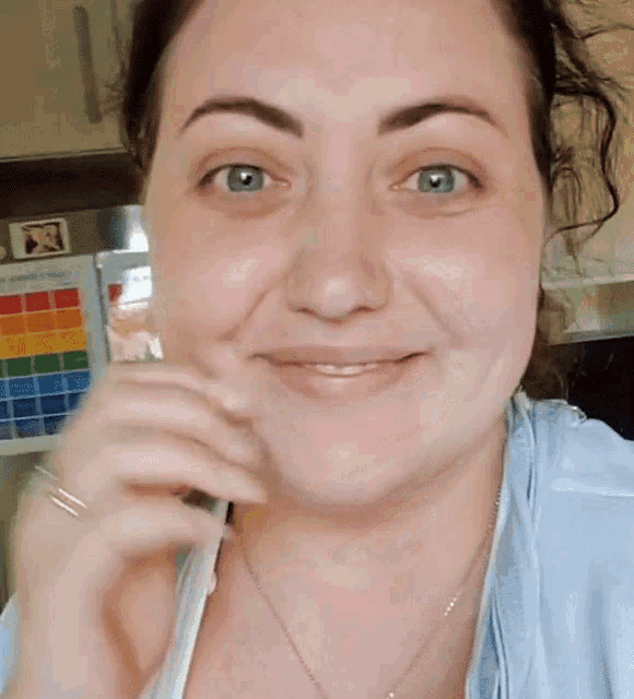 a woman is smiling in front of a fridge that has a rainbow on it