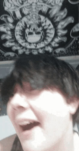 a close up of a person 's face with a skull on the ceiling in the background