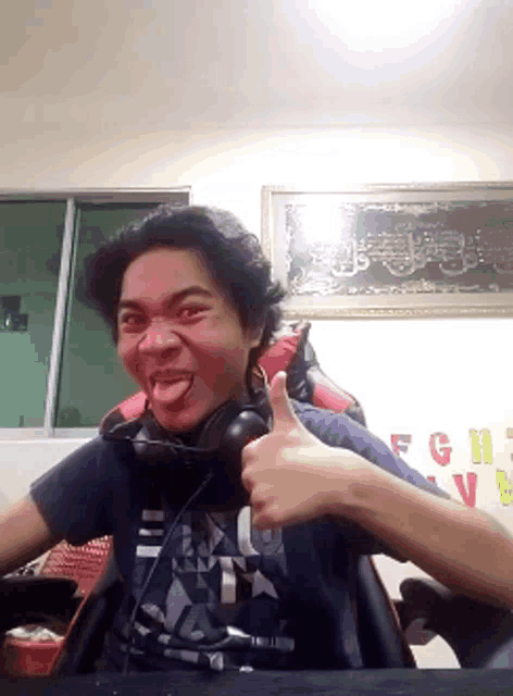 a man wearing headphones gives a thumbs up sign