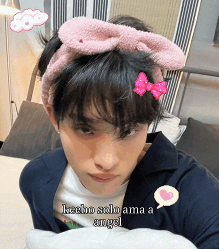 a person wearing a pink headband with the words keeho solo ama a angel on it