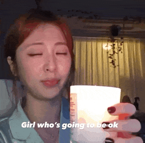 a woman is holding a candle in her hand with the words girl who 's going to be ok below her .
