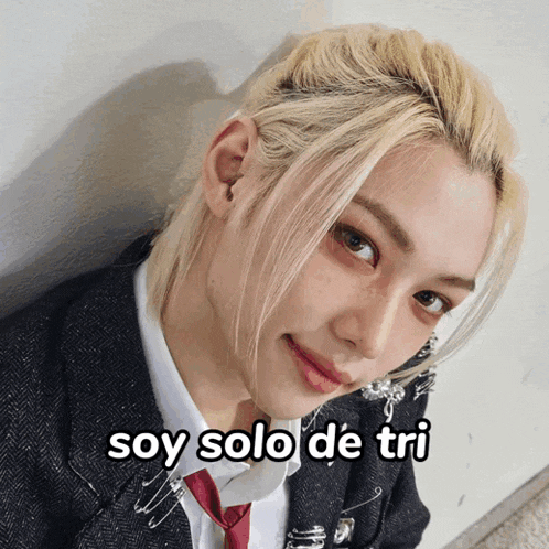 a man with blonde hair is wearing a suit and tie with the words soy solo de tri on the bottom