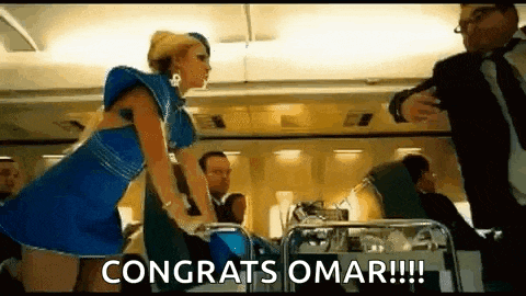 a woman in a blue dress is standing on an airplane with a man in a suit .