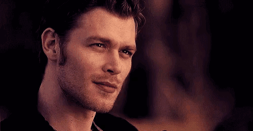 a close up of a man 's face looking at a woman .