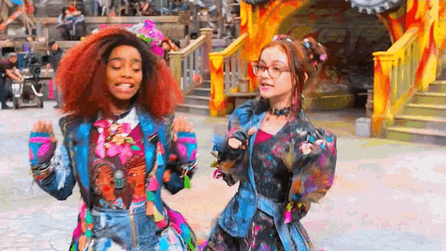 a couple of girls are standing next to each other in front of a building