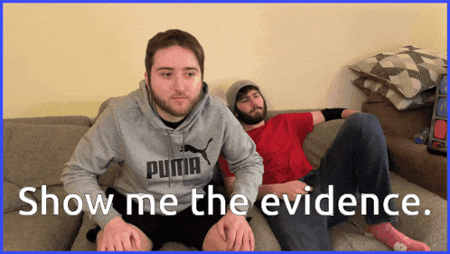two men are sitting on a couch with the words show me the evidence