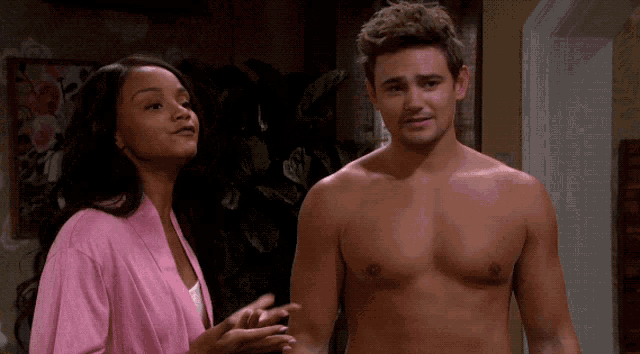 a woman in a pink robe stands next to a shirtless man in a pink robe