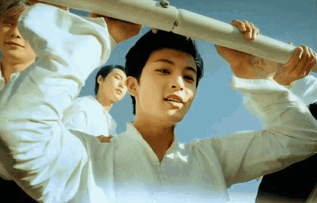 a man in a white shirt is holding a white pipe in his hands