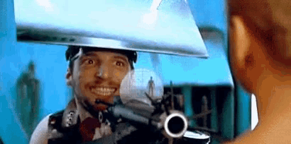 a man with a gun on his head is smiling and looking at the camera