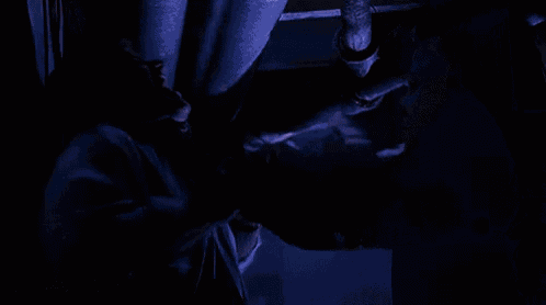a close up of a person wearing a white mask in a dark room .