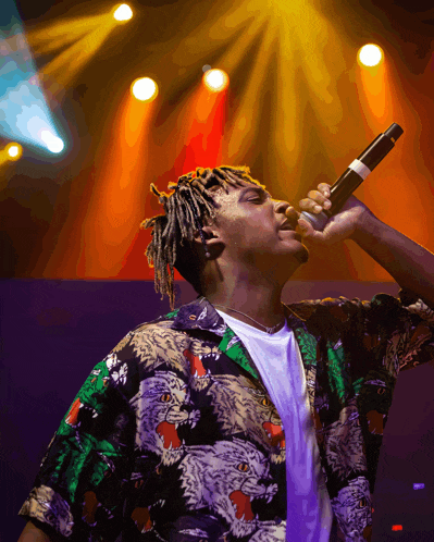 a man singing into a microphone with a tiger print shirt on