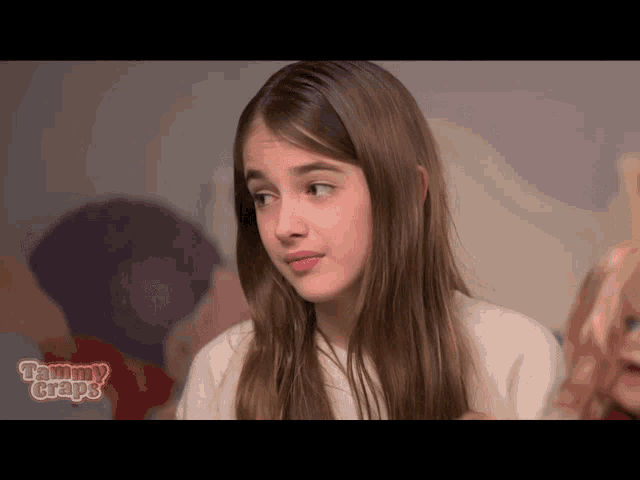 a girl is sitting in front of a sign that says mammy grapes