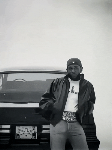 a man is standing in front of a car with a license plate that says california