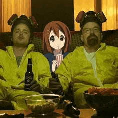 two men in yellow jackets are sitting on a couch with a picture of a girl on the wall behind them .