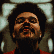 a close up of a man 's face with blood coming out of his mouth