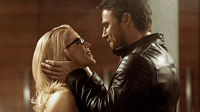 a man and a woman are looking at each other and the woman is wearing glasses