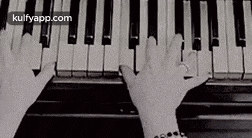 a person is playing a piano with their hands on the keys .