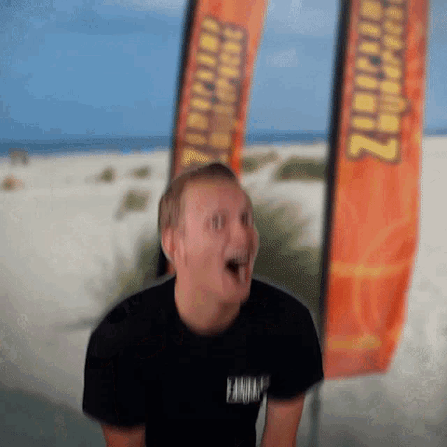 a man is making a funny face in front of a banner that says ' zippo '