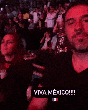 a man and a woman singing in front of a crowd with the words viva mexico on the bottom