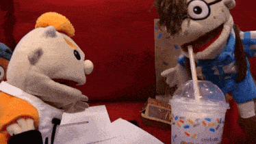 two stuffed animals drinking from a cup that says celebrate on it