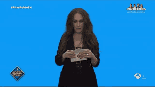 a woman is holding a piece of paper in front of a blue screen that says inocente