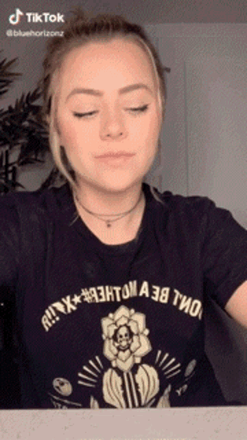 a woman wearing a black t-shirt that says tik tok