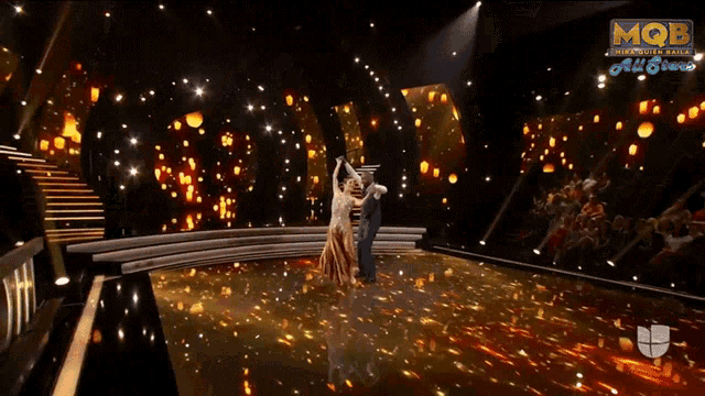 a man and a woman are dancing on a stage in front of a sign that says mob