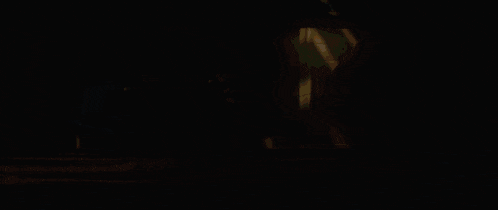 a person 's foot is shown in a blurry photo with a red light in the background