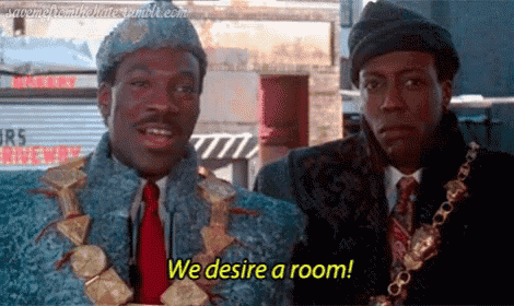two men are standing next to each other and one of them is wearing a necklace that says we desire a room .