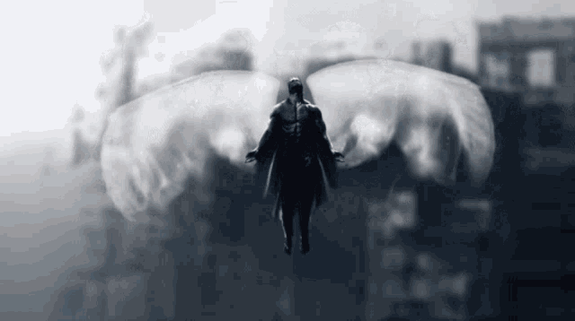 a black and white photo of a man with wings flying through the air