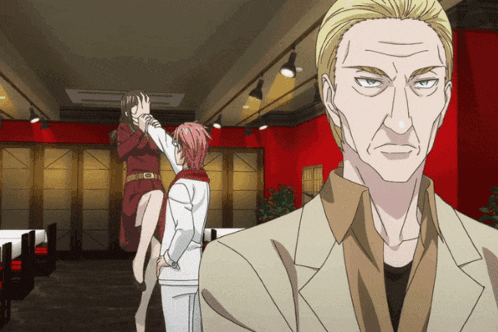 a man in a suit stands in front of a woman in a red dress and a man in a white suit