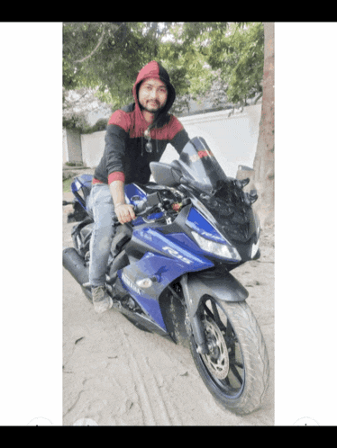 a man is sitting on a blue yamaha r15