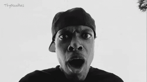 a black and white photo of a man making a funny face and says `` fuck out '' .