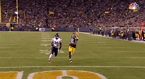 a football player with the number 30 on his jersey runs on the field