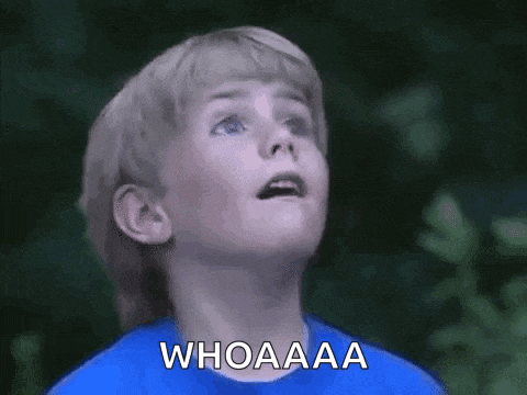 a young boy in a blue shirt is making a surprised face and saying `` whoaaa '' .