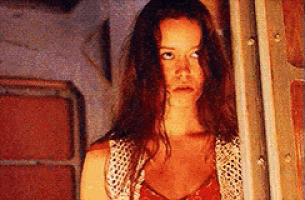 a woman with long hair is standing in a doorway