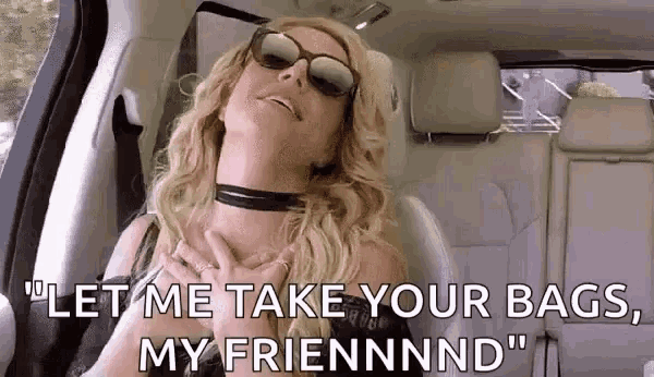 a woman wearing sunglasses and a choker is sitting in the back seat of a car with her hands on her chest .