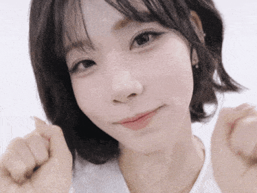 a close up of a girl 's face with a white shirt on
